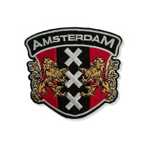 Könnte beinhalten: Gestickter Aufnäher mit dem Wort "AMSTERDAM" in Weiß auf einem schwarzen Banner. Der Aufnäher hat ein rot-schwarzes Schilddesign mit drei weißen Kreuzen und zwei goldenen Löwen. Geeignet für Kleidung oder Taschen.