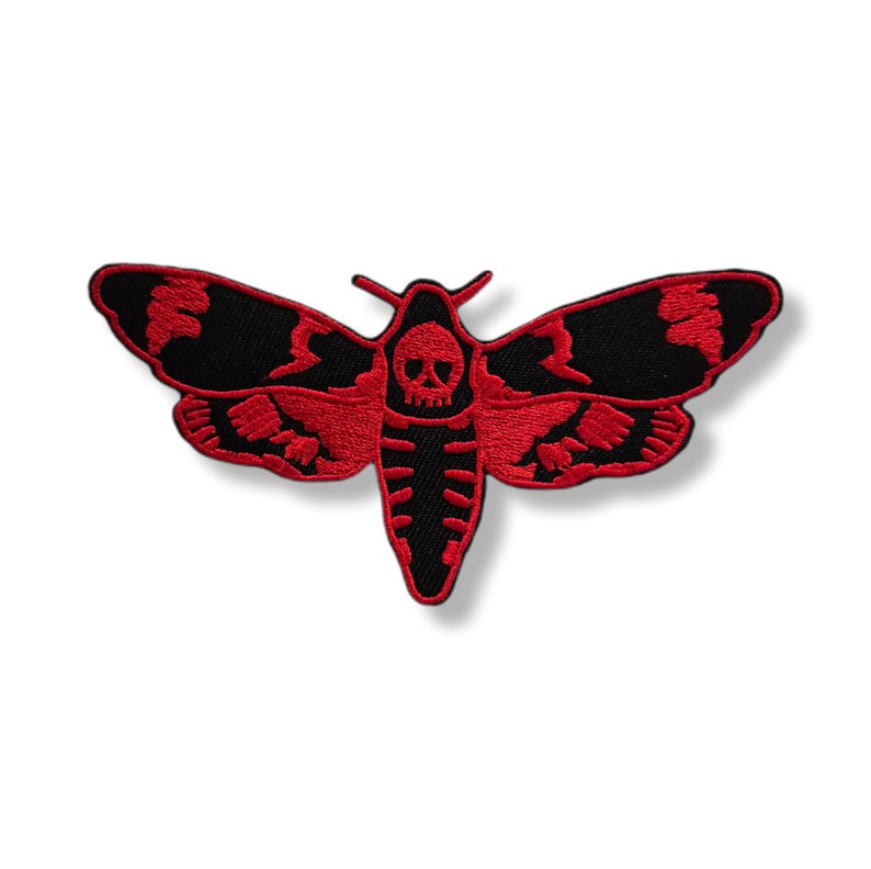 Peut inclure: Écusson brodé représentant un papillon de nuit avec un motif de crâne. Le papillon de nuit a des ailes noires avec des détails rouges et un corps rouge. Le patch est destiné aux vêtements ou accessoires.