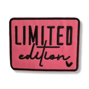 Puede incluir: Un parche bordado rectangular con fondo rosa y borde negro. El texto LIMITED está bordado en letras mayúsculas negras, y la palabra edition está bordada debajo en una fuente cursiva negra, centrada en el parche.