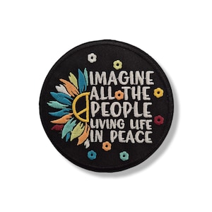 Könnte beinhalten: Ein runder, schwarzer, gestickter Aufnäher mit dem Text "IMAGINE ALL THE PEOPLE LIVING LIFE IN PEACE". Der Aufnäher zeigt ein farbenfrohes Sonnenblumen-Design mit einem Friedenssymbol in der Mitte.