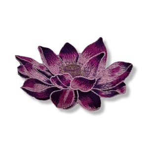 Può includere: Toppa ricamata a forma di fiore di loto nei toni del viola e del rosa. Il fiore ha più strati di petali, con viola più scuro alle punte e rosa più chiaro verso il centro. Il centro del fiore è di colore giallo dorato.