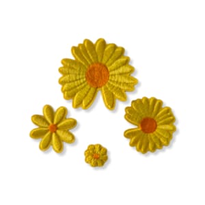 Op de afbeelding: Vier gele vilten bloemenpatches met oranje centra. De bloemen zijn van verschillende grootte en zijn in een cluster gerangschikt.