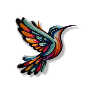 Puede incluir: Parche bordado de colibrí en vuelo, con una vibrante gama de colores. Las alas del pájaro son una mezcla de verde azulado, naranja, amarillo y rosa, delineadas en negro. El cuerpo del colibrí es azul y naranja, con un largo pico morado.