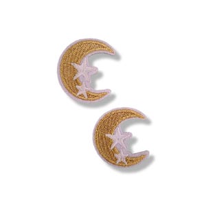 Puede incluir: Dos parches bordados con una luna creciente dorada con un diseño de estrella. Los parches tienen un reverso de color púrpura claro y son ideales para añadir a la ropa o los accesorios. Los parches tienen un tema celestial.