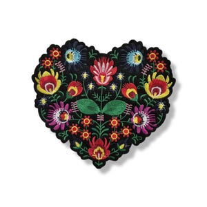 Peut inclure: Écusson brodé en forme de cœur sur fond noir. Il présente un motif floral coloré avec des fleurs rouges, jaunes, bleues et roses. L'écusson mesure environ 10 cm de large et 10 cm de haut.