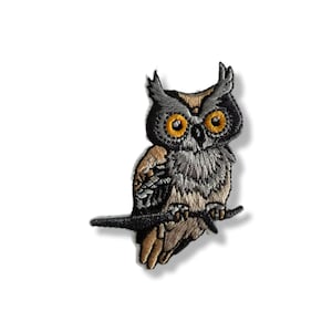 Peut inclure: Écusson brodé représentant un hibou détaillé, perché sur une branche. Les couleurs dominantes sont le gris, le marron et le jaune. Idéal pour les vestes, sacs ou autres articles en tissu.