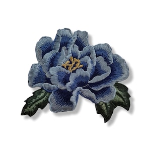 May include: Embroidered blue flower patch with detailed stitching. The flower has a layered petal design with a golden center and green leaves. This decorative patch can be used to embellish clothing or accessories.