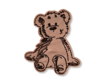 May include: A brown embroidered teddy bear patch with black stitching. The bear is sitting with its legs crossed and has a simple, cartoon-like design.