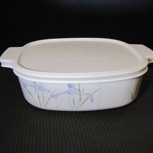 May include: White rectangular baking dish with a white lid. The dish has a floral design with blue irises and green leaves. The lid has the text "Springtime" embossed on it.