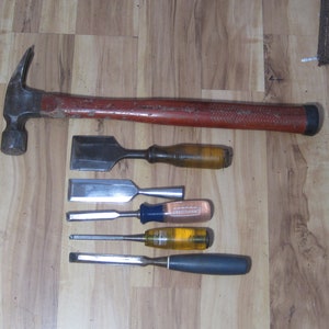 May include: A set of woodworking tools including a hammer, a chisel, and four wood carving chisels.