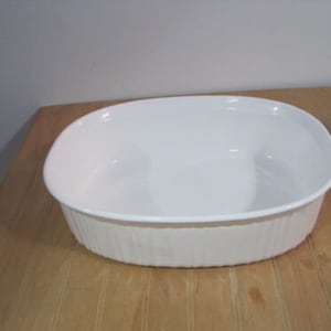 May include: White oval baking dish with a fluted rim.