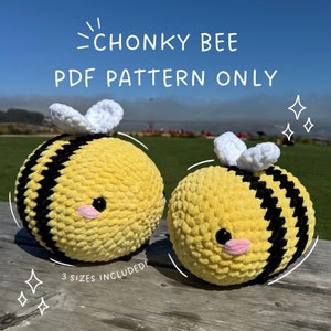 Peut inclure: Deux abeilles rondes faites à la main, jaunes et noires, crochetées, avec des ailes blanches et des joues roses. Le texte "CHONKY BEE PDF PATTERN ONLY" est en haut. Le texte "3 SIZES INCLUDED!" est en bas. Les abeilles sont sur une surface en bois.