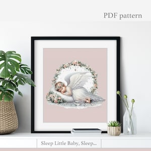 Puede incluir: Impresión enmarcada de un bebé ángel durmiente con alas blancas, una corona de flores y un vestido blanco. El ángel descansa sobre una almohada rodeada por una corona floral. El texto "Sleep Little Baby, Sleep..." está en la parte inferior. Las palabras "PDF pattern" están en la parte superior.