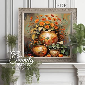 May include: A framed cross-stitch artwork featuring a still life of orange flowers in ornate vases. The artwork includes the text "YOUR Family PRINT Cross Stitch" and "PDF". The color palette includes orange, yellow, and green.