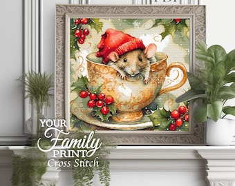 May include: A framed cross-stitch artwork featuring a mouse wearing a red hat, nestled inside a decorative teacup. The teacup is adorned with gold accents and holly berries. The text "YOUR Family PRINT Cross Stitch" is visible.