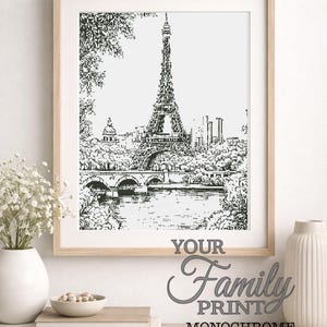 Puede incluir: Impresión monocromática de la Torre Eiffel en París, enmarcada en madera clara. La obra presenta el emblemático monumento, un puente y árboles. El texto "PARIS" está en la parte superior y "YOUR Family PRINT MONOCHROME" en la inferior.