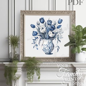 May include: A cross stitch pattern featuring a bouquet of blue and white tulips in a decorative vase. The design is displayed in a square frame with a light-colored border. The text PDF is visible in the top right corner of the image.