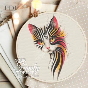 May include: A cross-stitch embroidery hoop featuring a stylized cat design. The cat has a white face with black, yellow, and red stripes. The text "YOUR Family PRINT Cross Stitch" is below the cat image. The hoop is set against a neutral background.