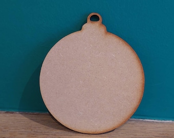May include: A plain, round, wooden ornament with a small hole at the top for hanging. The ornament is light brown and has a smooth surface.