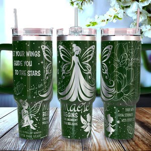 Puede incluir: Tres vasos aislados verdes con asas y pajitas. Cada vaso presenta un diseño de hada con citas inspiradoras como "Deja que tus alas te guíen hacia las estrellas" y "La magia comienza en el momento en que crees."