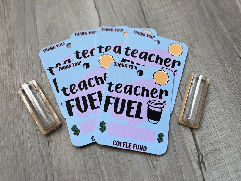 K&ouml;nnte beinhalten: Vier blaue und violette Geschenkkarten mit dem Text "Danke!" und "Lehrer-Treibstoff" mit einer Kaffeetassengrafik. Die Karten haben ein Loch in der oberen Ecke und liegen auf einer Holzoberfl&auml;che.