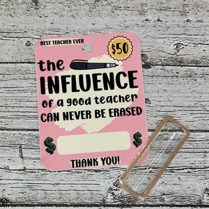 K&ouml;nnte beinhalten: Rosa Karte mit dem Text "BEST TEACHER EVER" und "the INFLUENCE of a good teacher CAN NEVER BE ERASED". Die Karte hat einen gelben Kreis mit dem Text "50 &euro;" und einen leeren Platz f&uuml;r einen Geldbetrag. Die Karte hat auch ein gr&uuml;nes Eurozeichen auf jeder Seite des leeren Platzes. Der Text "THANK YOU!" befindet sich am unteren Rand der Karte.