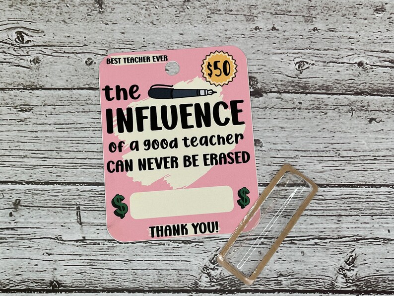 K&ouml;nnte beinhalten: Rosa Karte mit dem Text "BEST TEACHER EVER" und "the INFLUENCE of a good teacher CAN NEVER BE ERASED". Die Karte hat einen gelben Kreis mit dem Text "50 &euro;" und einen leeren Platz f&uuml;r einen Geldbetrag. Die Karte hat auch ein gr&uuml;nes Eurozeichen auf jeder Seite des leeren Platzes. Der Text "THANK YOU!" befindet sich am unteren Rand der Karte.