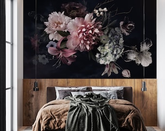 May include: A bedroom with a dark floral wallpaper featuring pink, white, and blue flowers. The bed has a brown blanket and a green throw blanket. There are two black pendant lights hanging from the ceiling.