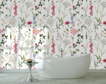 May include: A white bathtub sits in front of a wall covered in a floral wallpaper pattern. The wallpaper features pink, white, and blue flowers with green leaves on a white background.