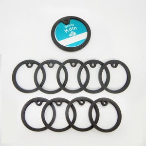 Könnte beinhalten: Ein Satz von zehn schwarzen Metallschlüsselringen mit einem einzelnen runden Schlüsselring mit einem blauen und weißen Design mit dem Text "Stadt Köln".