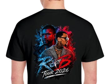 May include: Black t-shirt featuring a graphic design with two men in a red and blue color scheme. The text "R&B Tour 2026" is displayed in a stylized font. The design is centered on the back of the shirt.