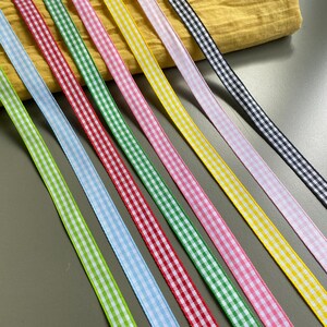 May include: Assortment of gingham ribbon in various colors, including green, yellow, blue, red, pink, and black. The ribbon is approximately 1/2 inch wide and has a checkered pattern.