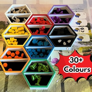 May include: A board game organizer with hexagonal compartments, each holding game pieces in various colors: beige, red, yellow, orange, blue, green, purple, and black. The image includes the text "30+ Colours".