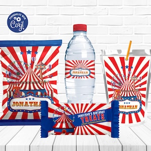 Puede incluir: Un conjunto de artículos para fiestas con temática de circo, que incluyen una bolsa de patatas fritas, una botella de agua, una bolsa de zumo y una barra de caramelo. Los diseños presentan rayas rojas y blancas, carpas de circo, norias y el nombre "Jonathan".