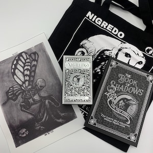El set de regalo NIGREDO Tarot incluye: baraja de tarot Nigredo - bolso de mano ermitaño - Impresión A4 Death - cuaderno físico del Libro de las Sombras
