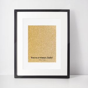 May include: A framed print with a gold glitter background and the text "You're a winner, baby!" - RuPaul Charles.