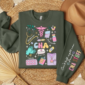 May include: A green sweatshirt with a colorful graphic design of medical tools and the text "CNA" in large letters. The right sleeve has the text "Can't talk right now Doing CNA STUFF".