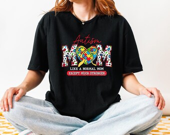 May include: Black t-shirt with a colorful puzzle piece heart and the text "Autism Mom Like a Normal Mom Except Much Stronger".