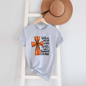 May include: Gray t-shirt with a basketball-shaped cross and the text "better is one day in your courts than a thousand elsewhere"  Psalm 84:10.