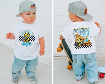 Puede incluir: Una camiseta blanca con un gráfico azul y amarillo que dice "Birthday Boy" y presenta un número 2 y una excavadora de dibujos animados. La parte posterior de la camiseta tiene un diseño similar con un gráfico de excavadora más grande.