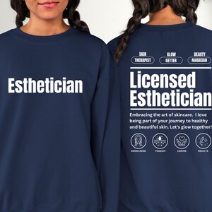 May include: Navy blue sweatshirt with the text "Esthetician" on the front and "Licensed Esthetician" on the back. The back also includes the text "Embracing the art of skincare. I love being part of your journey to healthy and beautiful skin. Let's glow together!" with four icons representing knowledge, passion, caring, and results.