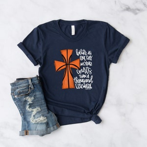 May include: A navy blue t-shirt with a basketball-shaped cross graphic and the text "better is one day in your courts than a thousand elsewhere"  Psalm 84:10.
