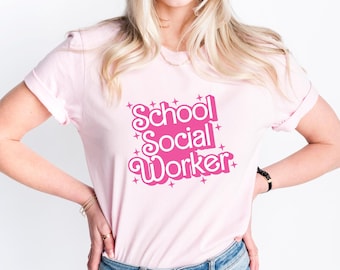 Puede incluir: Una camiseta rosa con el texto "School Social Worker" en rosa con contornos blancos y brillos. El texto está en una fuente retro.