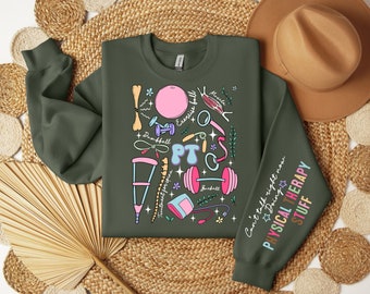 Puede incluir: Una sudadera verde oscuro con una ilustración colorida de equipos de fisioterapia y el texto "Can't talk right now Doing Physical Therapy Stuff".