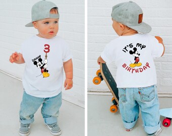 May include: A white t-shirt with a Mickey Mouse graphic and the text "It's my birthday" on the back. The front of the shirt has a Mickey Mouse graphic holding a number 3 balloon and the text "Danny".