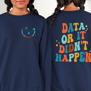 May include: Navy blue sweatshirt with a graphic on the front that says "Data or it didn't happen" with a line graph and stars. The back of the sweatshirt has the same text in a retro font with colorful letters.