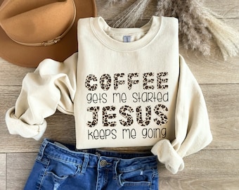 May include: A cream-colored sweatshirt with a leopard print design. The text "COFFEE gets me started JESUS keeps me going" is printed on the front of the sweatshirt.