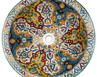May include: A round, hand-painted ceramic sink basin with a vibrant, intricate design. The basin features a central drain hole and is adorned with a colorful pattern of blue, yellow, red, and green floral and geometric motifs. The rim is bordered with a decorative pattern.