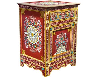May include: A red, hand-painted wooden nightstand with intricate floral and geometric designs in yellow, white, and blue. The nightstand features a single drawer and a decorative top, showcasing a blend of artistry and functionality.