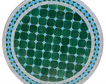 May include: Round green and blue mosaic tile tabletop. The center of the table is green with a geometric pattern of smaller blue squares. The outer edge of the table is a border of alternating blue and white diamond shapes.